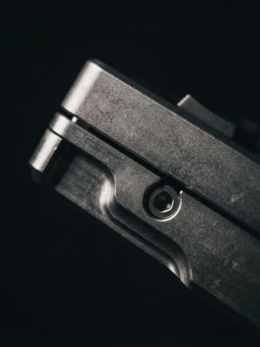Extreme macro-focused product photography of a raw 6063 aluminum keyboard side profile, low-key directional side-lighting with deep shadows
