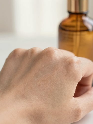 Soft close-up of clean skin with natural texture, elegant amber glass skincare bottle in the background, warm editorial photography, soft natural window light, shallow depth of field