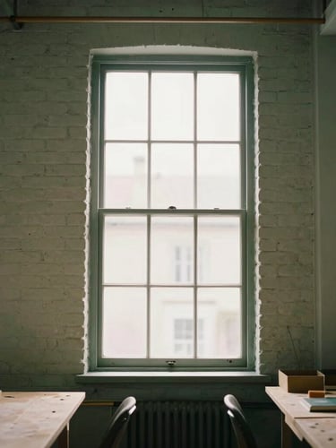 Environmental portrait of a community workshop in a high-ceilinged brick building, soft natural window light, muted forest green tones, shallow depth of field, 35mm