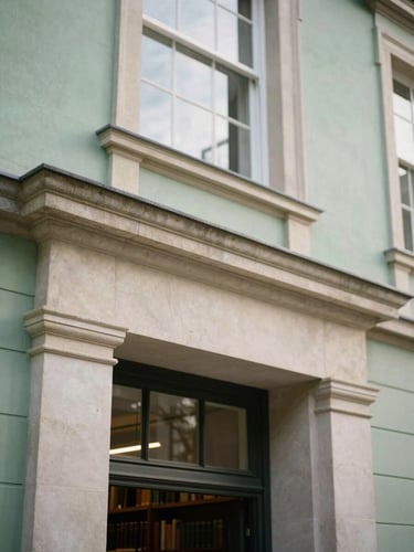 An architectural detail of a classical stone library entrance, soft morning window light, shallow depth of field, 35mm