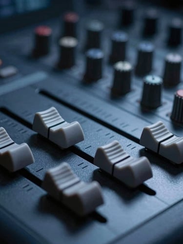 Macro close-up of a professional solid-state broadcast console, faders aligned, cool low-key studio lighting with deep blue and charcoal shadows, sharp 35mm focus.