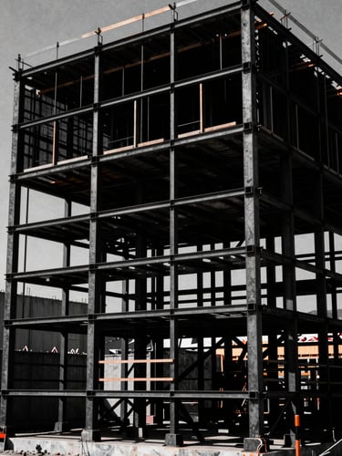 Cinematic wide shot of a physical billboard construction set in harsh midday sun, deep black shadows, stark industrial steel framing, 35mm film