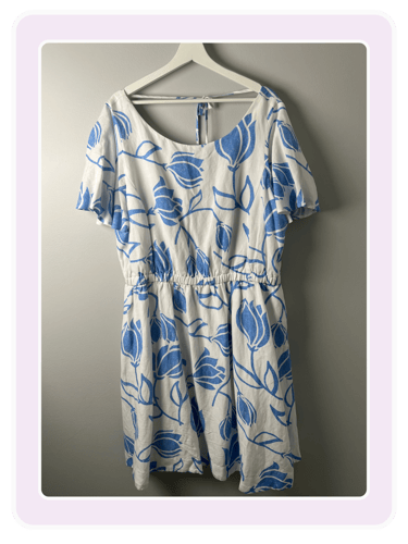 LB White short-sleeve summer dress with a blue floral tulip print and elastic waist on a hanger.