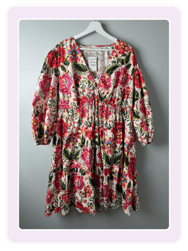 Floral print long sleeve mini dress with a V-neck and ruffled tiers on a white hanger.