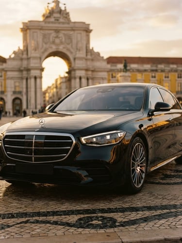 Low-angle heroic portrait of a pristine black executive sedan parked near a historic Lisbon monument at golden hour, warm lighting, shallow depth of field