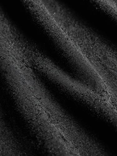 Extreme macro close-up of high-density black heavyweight cotton fabric texture, harsh direct studio lighting, deep shadows, 35mm film