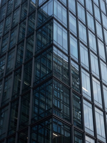 Macro photograph of clean modern glass skyscraper facade reflecting cool morning light, sharp geometric angles, deep navy tones, 35mm