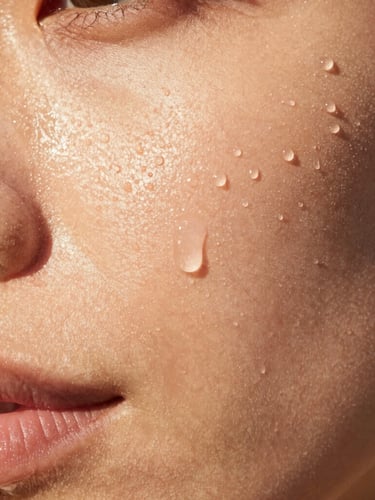 Extreme close-up of dewy hydrated skin texture in direct bright sunlight, showing natural pores and a soft golden hour glow, no airbrushing.