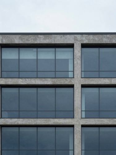 Minimalist architectural photography of a modern concrete and glass building facade, soft overcast daylight, cool slate and deep blue tones, sharp focus, 35mm