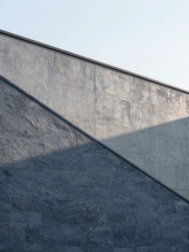 Minimalist concrete architectural facade with clean diagonal lines, soft overcast daylight casting subtle shadows on slate grey surfaces, sharp focus, 35mm