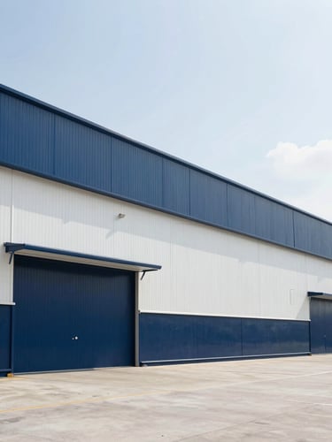 Wide-angle architectural shot of a modern, clean logistics hub exterior in bright neutral daylight, crisp navy and white tones, sharp focus.