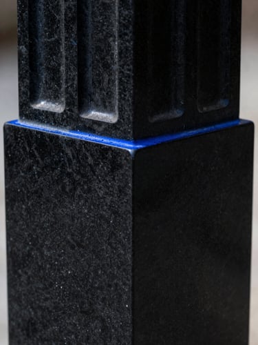 Macro shot of monolithic black obsidian architectural column, sharp geometric edges, subtle royal blue rim light, high contrast.
