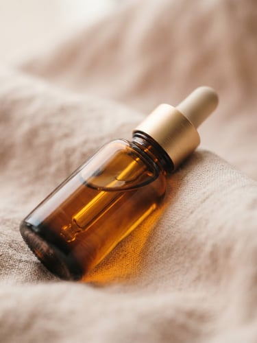 Warm editorial photography of a glass dropper bottle resting on a soft beige linen background, diffused morning window light, macro depth of field.