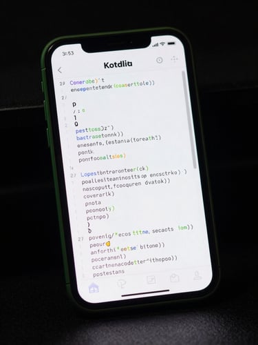 Low-key studio shot of a physical Android device screen displaying a clean Kotlin IDE code block, sharp green edge-lighting reflecting off the glass.