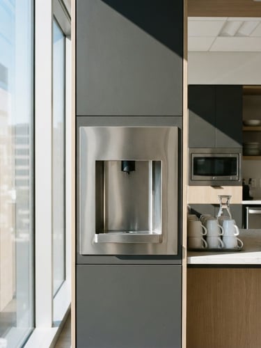 Sleek stainless steel water dispenser integrated into a sunlit modern office kitchen, crisp glass reflections, high-contrast corporate minimalism, 35mm lens