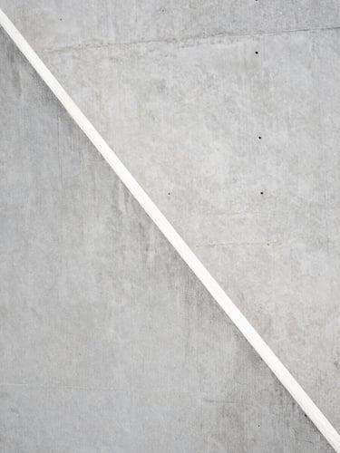 Close-up of raw board-formed concrete texture, sharp diagonal shadow, minimalist architectural detail, high contrast, 35mm