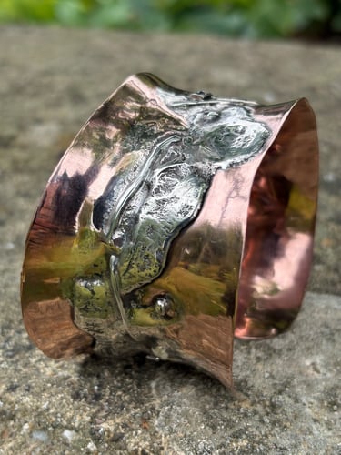 A wide copper cuff fused with reticulated silver