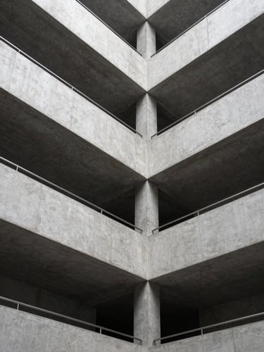 Architectural crop of a modern concrete and steel corporate atrium, sharp natural daylight, clean structural lines.