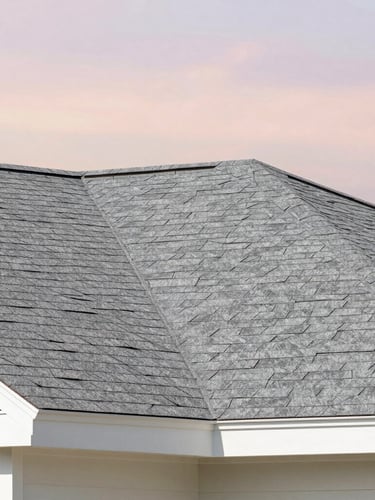 Close-up of pristine gray architectural shingles on a modern roof under soft daylight, clean geometric composition