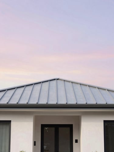 Straight-on architectural photo of a modern residential home with a clean metal roof under a bright pastel sky, soft natural daylight, 35mm
