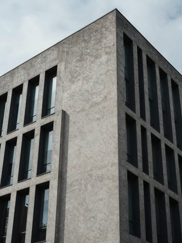 Abstract geometric shadows on a modern concrete and steel corporate building facade, cool overcast light, architectural angle.