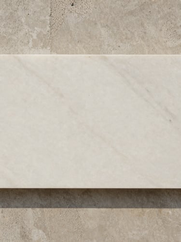 Abstract close-up of raw materials, a slab of honed white marble resting against textured cast concrete, soft natural side lighting, neutral tones