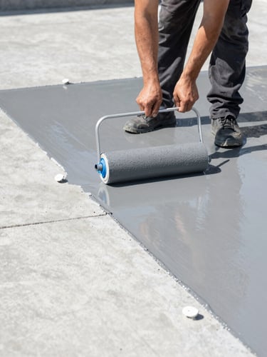 A professional technician rolling wet gray epoxy coating onto a clean concrete floor, crisp edges, bright white construction work lights, high-contrast details