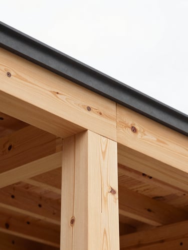 Close-up of a precise carpentry joint connecting a new structural timber beam to an existing roofline under bright overcast daylight.