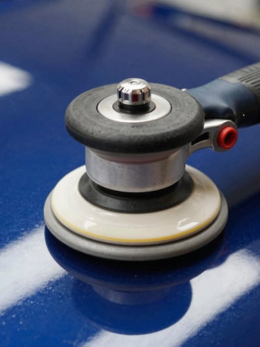 Extreme macro shot of a dual-action rotary polisher on pristine dark blue paint, bright overhead studio lights reflecting a sharp line, 50mm automotive photography