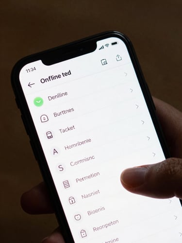 Close crop of an Android phone screen showing a clean task-list interface with offline status indicator, natural overhead desk light, fingers resting near the screen edge