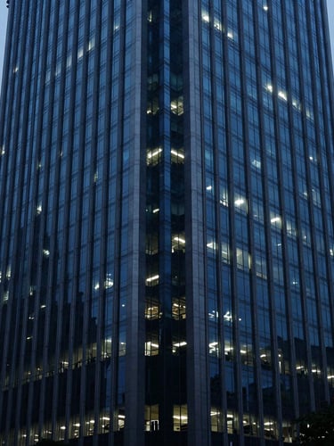 A sharp corporate office building reflecting cool blue-hour light in Mumbai's financial district, architectural depth of field, 35mm