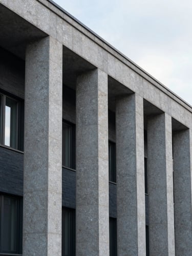Close-up of a modern Swiss building facade with clean granite columns and soft morning light, architectural crop, 35mm lens