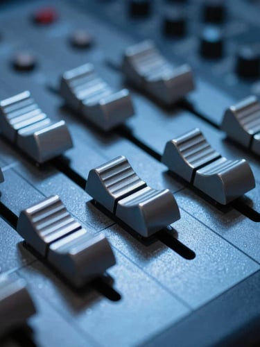 Low-light macro shot of metallic faders on an analog mixing console, cold-cathode blue light reflecting off the brushed metal surface