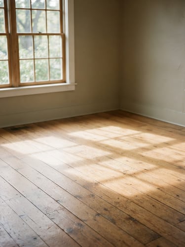 A warm, soft-lit empty room with natural window light casting soft shadows on a hardwood floor, muted sage and warm taupe tones, 35mm film look.