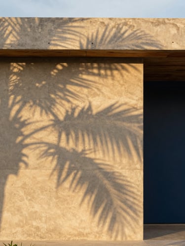 Architectural detail of a modern concrete and local wood villa in Tulum, sun-dappled shadows on warm sandy concrete wall, golden-hour light, 35mm