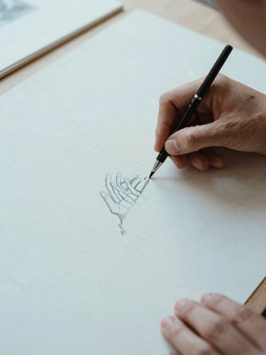 Hands carefully aligning a delicate charcoal sketch on a linen mat board, soft natural daylight, shallow depth of field, 35mm