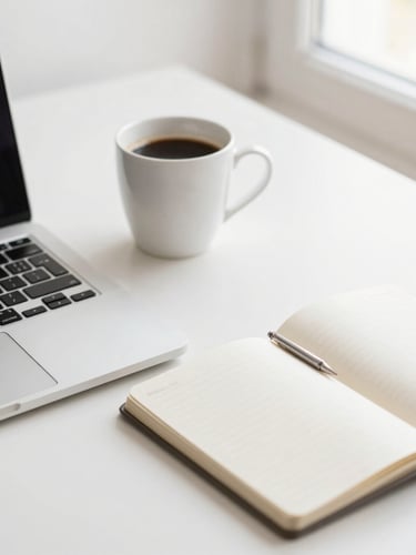 A clean modern workspace flat-lay with a laptop, notebook, and coffee cup, bright natural daylight, soft neutral tones, shallow depth of field, 35mm
