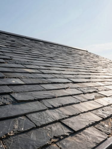 Wide architectural shot of a newly installed premium slate roof under bright crisp daylight, highlighting clean modern lines against a sharp sky.