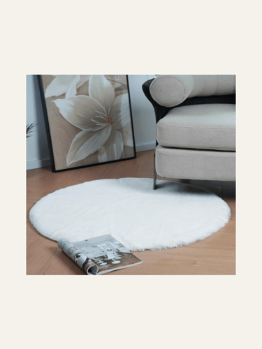 a picture of a round faux rabbit fur rug in front of an armchair