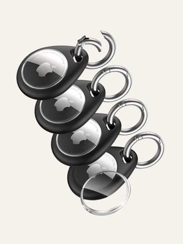 Set of four Apple AirTags in black protective keychain cases with silver carabiner rings.