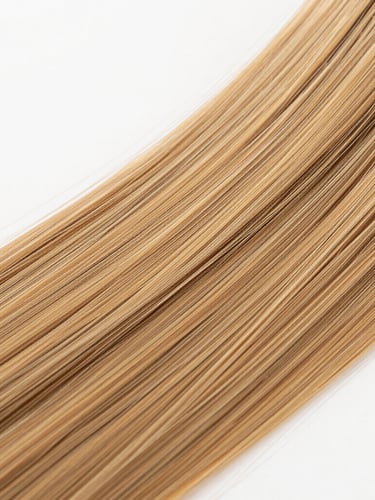 Macro detail shot of premium human hair wig strands reflecting soft golden light, clean minimalist studio backdrop