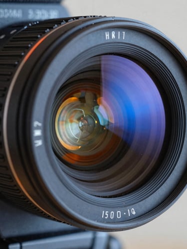 Macro close-up of a professional cinema camera lens, glass reflecting cool studio blue and warm orange lights, sharp focus, 35mm