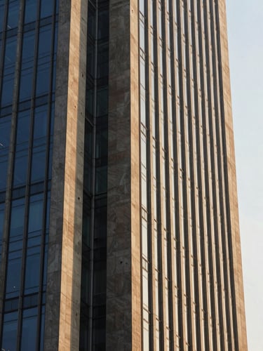 Architectural detail of a modern concrete and steel financial tower in Mumbai, sharp angles, soft golden hour sunlight reflecting off glass panels, 35mm