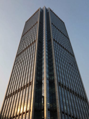 Architectural wide angle of a modern financial tower in Mumbai at golden hour, soft light reflecting off steel and glass, deep blue and gold tones, 35mm photography