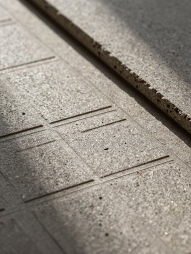 Extreme close-up of heavy stone textured paper collateral with blind debossed geometric grid alignment lines, sharp directional shadows