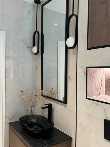 a bathroom with beautiful pendants and tall mirror and ample storage