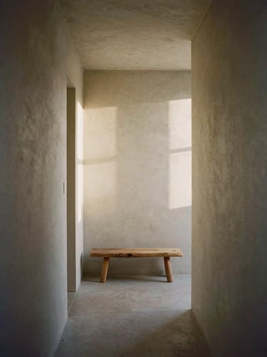 Straight-on architectural photograph of a minimalist residential hallway, soft morning light casting long shadows on microcement walls, a single rustic wooden bench, 35mm film.