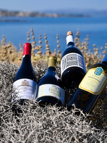 four greek bottles of wine on a thyme area