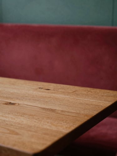 A cozy Scandinavian-style restaurant interior with soft, diffused side-lit daylight illuminating a rustic wooden table, shallow depth of field, warm editorial photography.