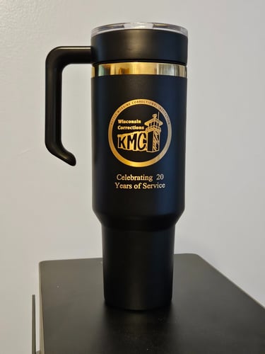 a black and gold mug with a logo on it